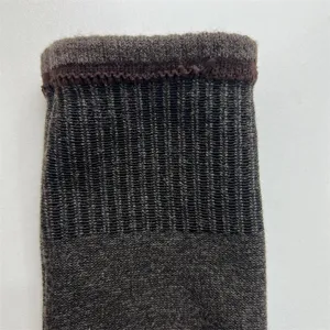Detailed view of brown merino wool sock cuff, featuring elastic ribbed knit texture.