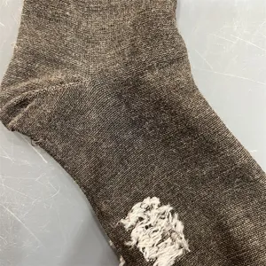 Close-up detail of brown merino wool knit sock texture, showing soft warm material and craft.