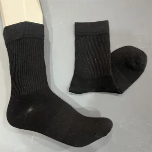 Black merino wool ribbed mid-calf sock close-up, showing detailed knit texture and fabric quality.