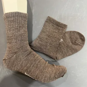 Detail view of solid color merino wool mid tube socks showing texture and foot form fit display.