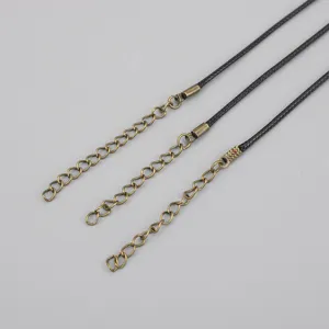 Detailed macro view of black waxed necklace cords featuring antique bronze extender chains