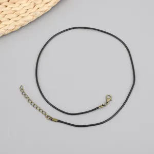 Detail view of black wax necklace cord with vintage bronze lobster clasp and chain