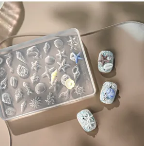 Makroansicht der 3D-Silikon-Nagelform im Meeresdesign mit Muscheln und Seesternen