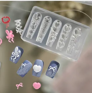 Detailansicht der 3D-Silikon-Nagelkunstform mit Schleifen- und Herzspitzenmustern