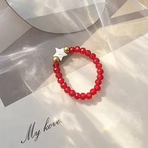 Close-up of a Bohemian red glass beaded ring featuring a white shell star detail