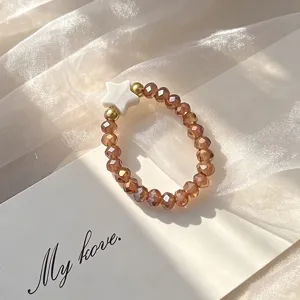 Detailed macro view of bohemian elastic ring with amber glass beads and white shell star detail
