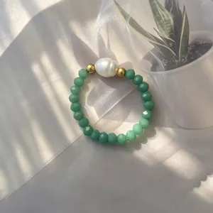 Detailaufnahme eines handgefertigten elastischen Rings mit Barockperle und Perlen