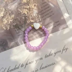 Elegant handmade purple crystal beaded ring featuring a white shell heart center detail.
