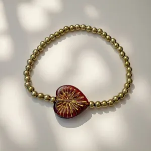 Detailansicht eines vergoldeten Edelstahl-Perlenarmbands mit rotem Herz-Mittelstück