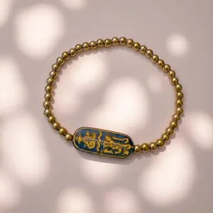 Detaillierte Ansicht des eleganten goldverzierten Runenanhängers am goldenen Perlenarmband