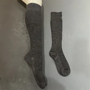 Primo piano dettagliato di calze alte a costine grigio scuro, che mostrano una trama fine e tessuto.