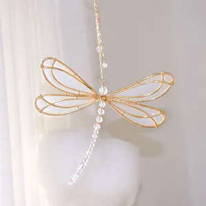 Detailed view of a golden metal dragonfly suncatcher with iridescent crystal beads