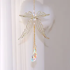 Detail view of a metal dragonfly suncatcher featuring iridescent hanging crystal prisms