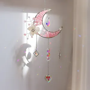 Gedetailleerd overzicht van een maan zonnevanger met roze stenen en hart kristal prisma.