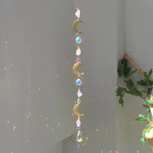Decorative natural crystal suncatcher with golden moon charms creating dreamlike light reflections