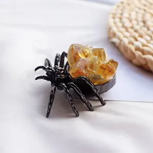 Vue détaillée d'une figurine d'araignée en métal noir avec des cristaux bruts jaunes