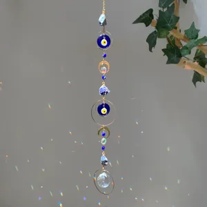 Bohemian crystal suncatcher with evil eye beads and raw stones hanging in sunlight