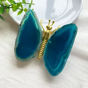 Macro view of a natural blue agate slice butterfly ornament with a golden metal body.