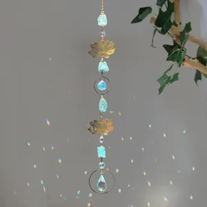 Detail of crystal suncatcher with raw green stones and gold lotus in natural sunlight