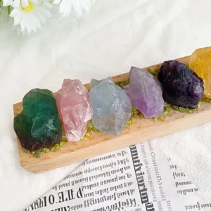 Macro view of colorful natural raw crystals arranged on a minimalist wooden light base.
