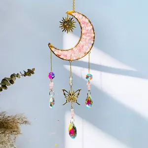 Detail of crystal suncatcher with moon and butterfly charms casting rainbow light
