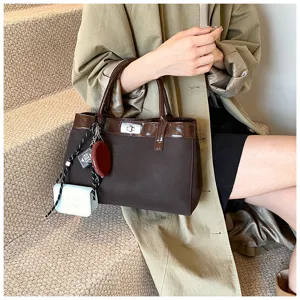 Detail shot of a retro brown lock tote bag with chic charms and khaki commuter outfit.