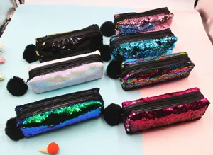 Detalle de estuches de lentejuelas reversibles con suaves pompones negros colgantes