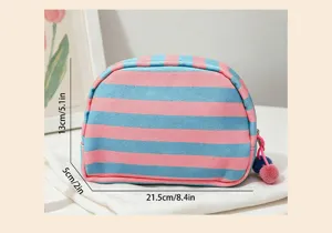 Detailed view of the pink and blue striped shell-shaped makeup bag with pom-poms.