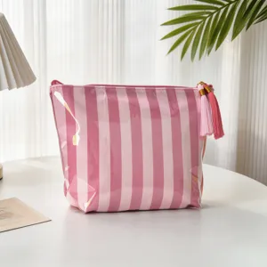 Detail der rosa-weiß gestreiften PVC-Kosmetiktasche mit elegantem Quasten-Reißverschluss