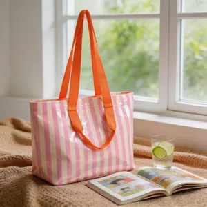 Dettaglio di una borsa tote in PVC a righe rosa con manici arancioni molto brillanti.