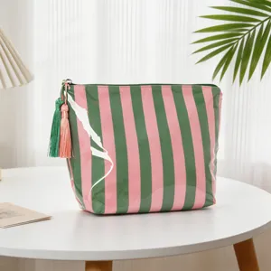 Detailansicht der wasserdichten rosa-grün gestreiften PVC-Make-up-Tasche mit Quasten