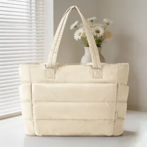 Vue d'ensemble du sac cabas matelassé crème dans une pièce avec vase fleuri