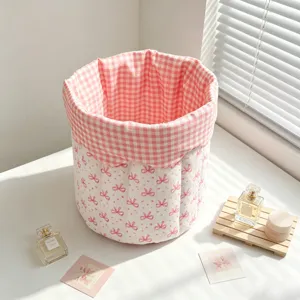 Macro view showing the quilted texture and pink bow pattern of the fabric storage basket.