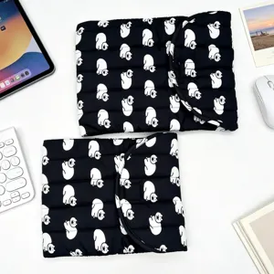 Vista detallada de fundas acolchadas negras para portátil con gatos blancos en escritorio