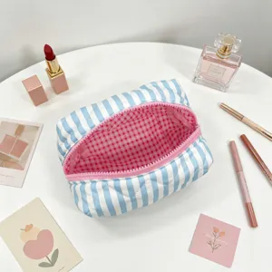 Close-up of a blue and white striped octagonal makeup bag with pink gingham lining