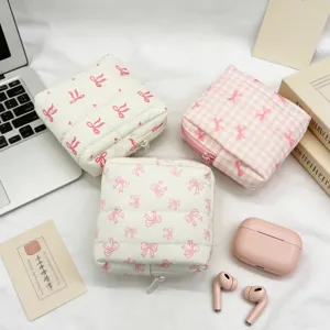 Detalle de tres bolsas de almacenamiento acolchadas con bonitos lazos de color rosa.