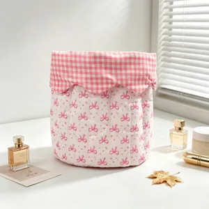 Pink bow quilted storage bag on a desktop with elegant perfume and soft window light