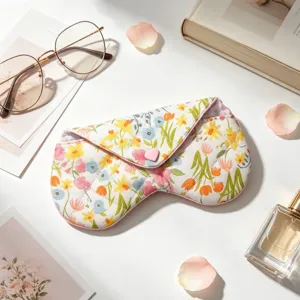 Vista detallada de un estuche para gafas de tela floral con un botón de corazón