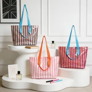 Gruppo di borse tote a righe in PVC colorate su un elegante espositore bianco