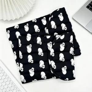 Primer plano de fundas acolchadas para portátil en blanco y negro con dibujo de gato en escritorio