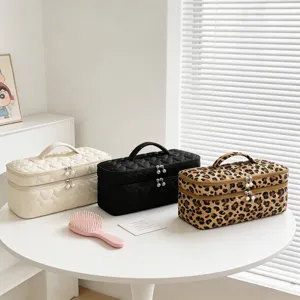 Large capacity makeup storage bags in quilted heart and leopard patterns on a white table