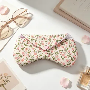 Detalle de funda para gafas en tela acolchada con flores y cierre de botón de corazón