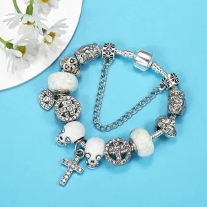 Luminous punk skull charm bracelet with glass beads and cross pendants on blue background