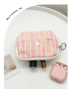 Detail view of pink tweed coin purse used for organizing lipsticks and small items