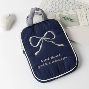 Detalle del lazo plateado bordado en una funda para tableta azul marino muy elegante