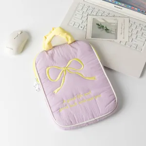 Primer plano de funda acolchada morada para portátil con lazo bordado y asa amarilla