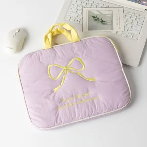 Primer plano de funda morada para portátil con bordado de lazo amarillo y texto