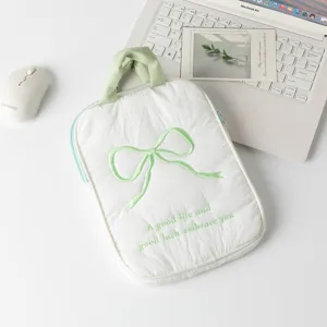 Vista detallada de la funda blanca acolchada para portátil con un lazo bordado.