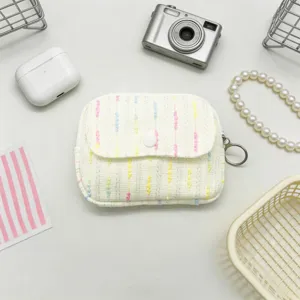 Detail view of a cute white tweed coin pouch with colorful stripes and key ring