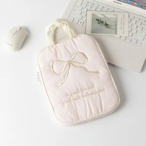 Detalle de una funda acolchada rosa para iPad con lazo bordado y frase inspiradora